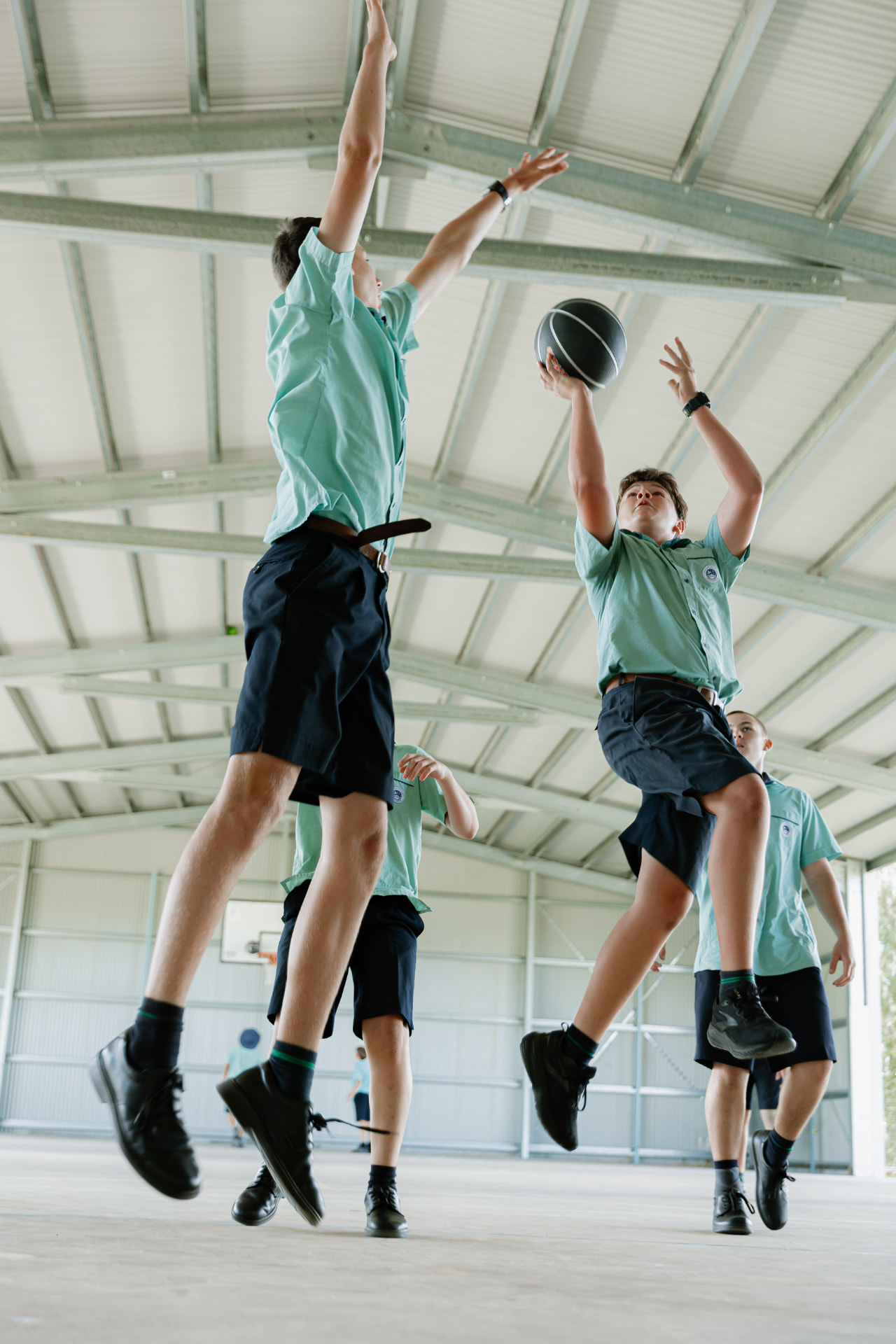 Border Rivers students leaping for a basketball in the College covered sports court